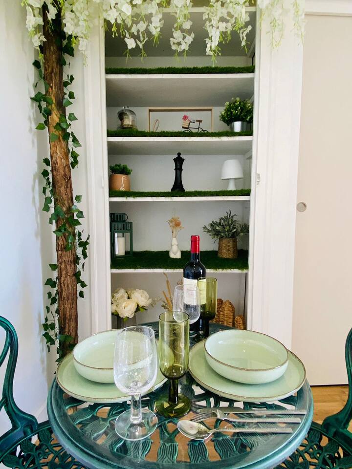 Table de dîner romantique en fer forgé avec vin rouge et étagère fleurie