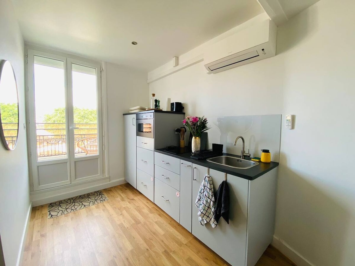 Cuisine moderne équipée avec four, plaques de cuisson, climatisation et baie vitrée
