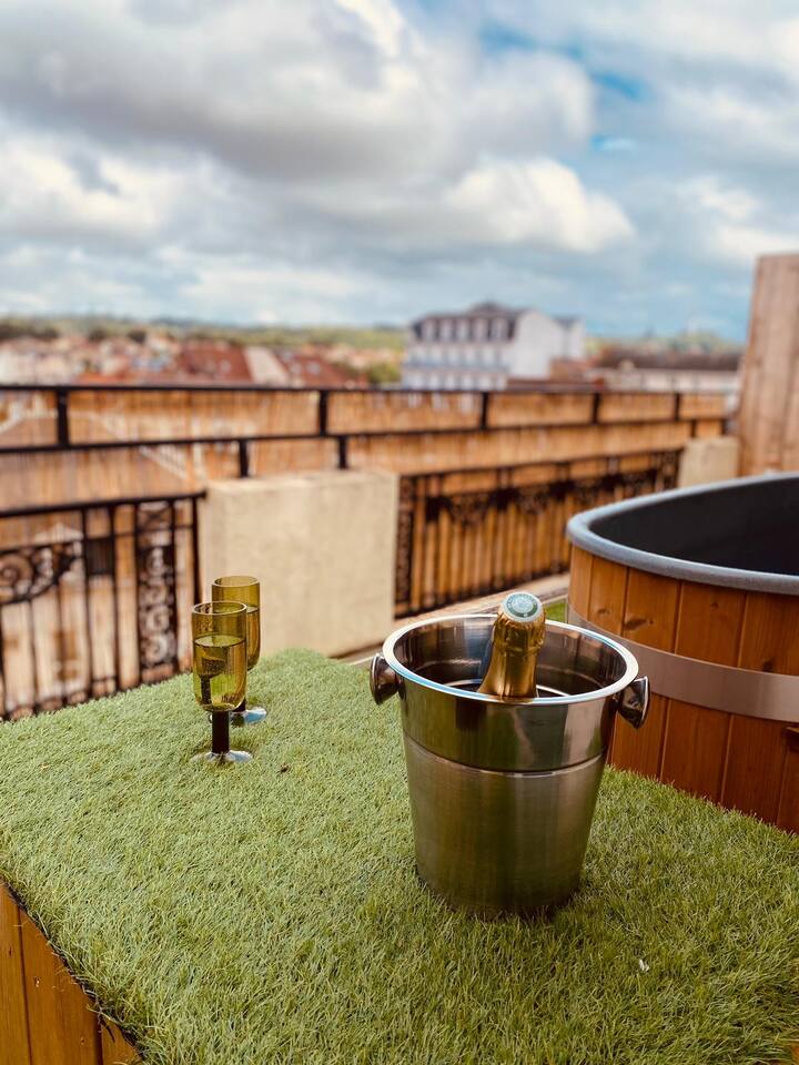Seau à champagne frais et flûtes sur la terrasse devant le bain nordique et vue sur Vichy